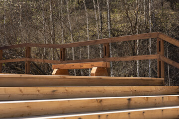 Public recreation area for rest upstairs in Nature Park. Wooden stairs, bench from terrace deck boards. Modern seating zone on staircase outdoors