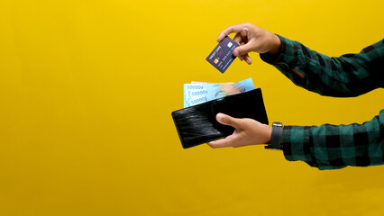 Hand Taking a Credit Card Out of a Wallet Full of Money to Make an Online Purchase, Isolated on a...