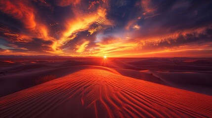 A fiery sunset casting a warm glow over a vast expanse of desert dunes.