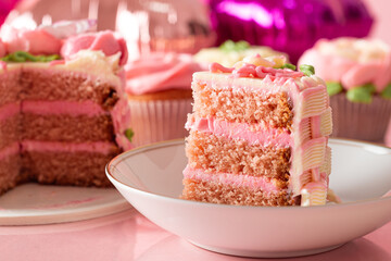 Slice of cake on a plate. Close up, pink colors.