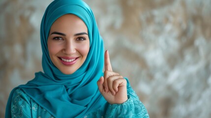 Confident senior Arabic female in elegant hijab and turquoise attire, smiling and pointing upwards,...