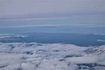 [空撮] 雲が一面に広がる地上の風景を飛行機から眺める
