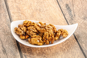 Cracked unshelled walnut in the bowl