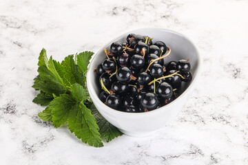 Juicy black currant berries in the bowl