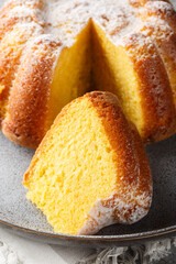 Citrus Orange Pound Cake sprinkled with powdered sugar close-up on a plate on the table. Vertical