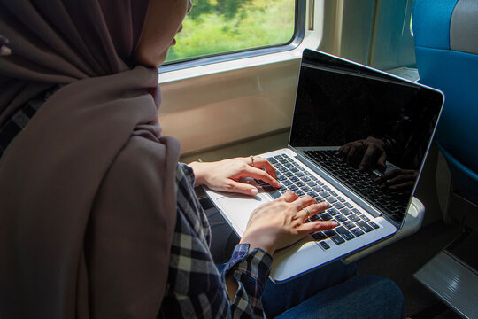 close up of woman hand typing on laptop computer while sitting in the train wagon
