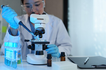 Scientist working in laboratory using micropipette Mixing liquid chemicals with genetically modified samples under a biotechnology microscope. Development of microbiology research experiment.