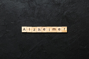 Alzheimer word written on wood block. Alzheimer text on cement table for your desing, concept