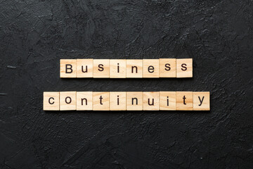 Business Continuity word written on wood block. Business Continuity text on cement table for your...