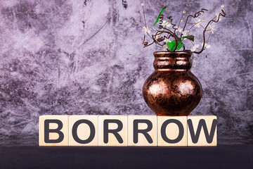 Word BORROW made with wood building blocks on a gray back ground