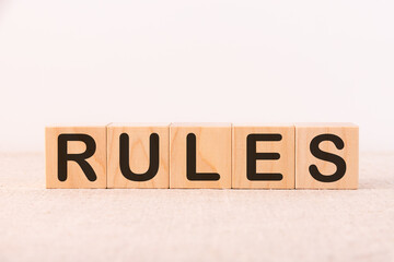 RULES word concept written on wooden cubes blocks lying on a light table and light background