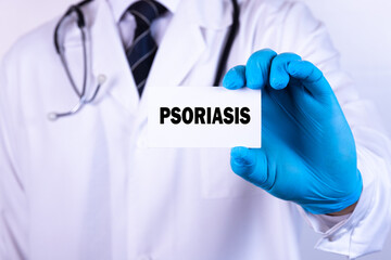 Doctor holding a card with text Psoriasis medical concept