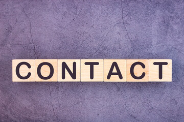 CONTACT word made with wood building blocks.