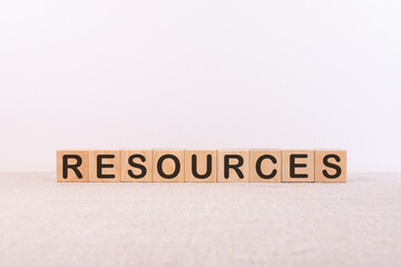 RESOURCES word concept written on wooden cubes lying on a light table and light background.