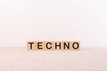 TECHNO word concept written on wooden cubes blocks lying on a light table and light background