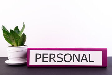 PERSONAL word concept written on a folder lying on a dark table with a flower in a pot on a light background - Powered by Adobe
