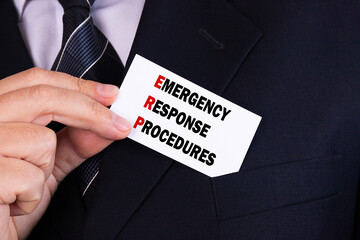 Businessman putting a card with text emergency response procedures in the pocket