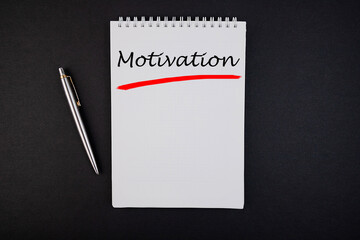 Motivation notepad writing concept on dark background with pen