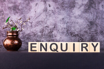 Word ENQUIRY made with wood building blocks on a gray background