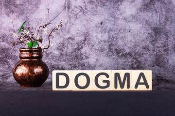 Word DOGMA made with wood building blocks on a gray back ground