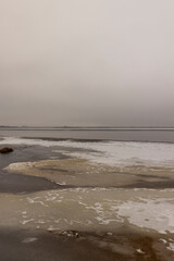 frozen lake in winter in cloudy weather, ice on the lake ts