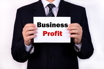 Businessman holding a card with text Business Profit
