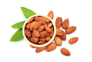 Almonds in wooden bowl with green leaf isolated on white background.