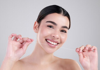 Happy woman, portrait and teeth with dental floss for cleaning, hygiene or treatment on a gray...