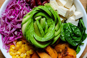 Salad bowl with avocado, baked sweet potatoes, spinach, red cabbage with honey ginger soy sauce...