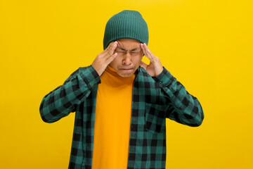 Young Asian man in beanie hat and casual shirt holding his head appears worried about his future,...