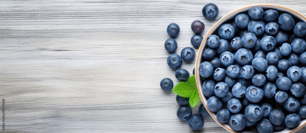 Aufkleber a summery image of ripe blueberries arranged in a blue bowl on a white wooden surface seen from abov