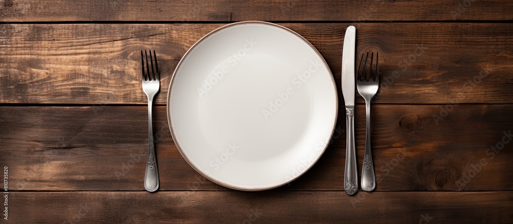 Poster an overhead view of an empty vintage white plate placed on a black wooden table is captured in this 