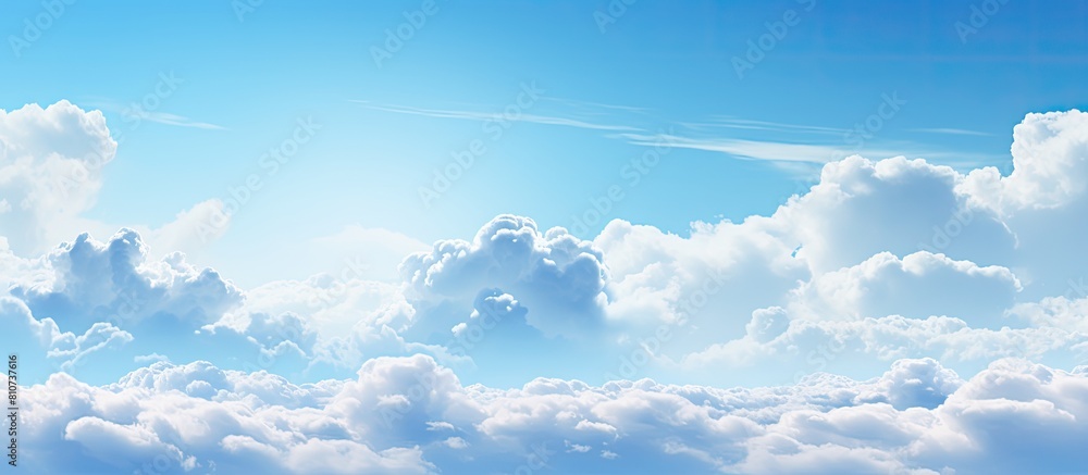 Fototapete A background image showing a spacious expanse of blue sky and fluffy clouds perfect for adding text or other elements. Creative banner. Copyspace image