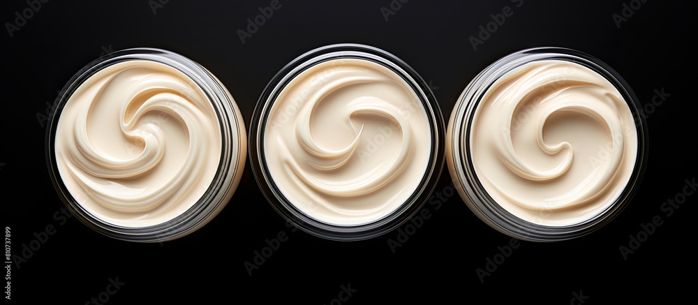 Poster A top view of three isolated face cream jars on a black background with copy space for an image