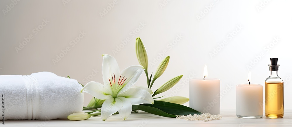 Poster a serene wellness setting showcases a beautiful lily a towel a candle and an oil bottle on a white b