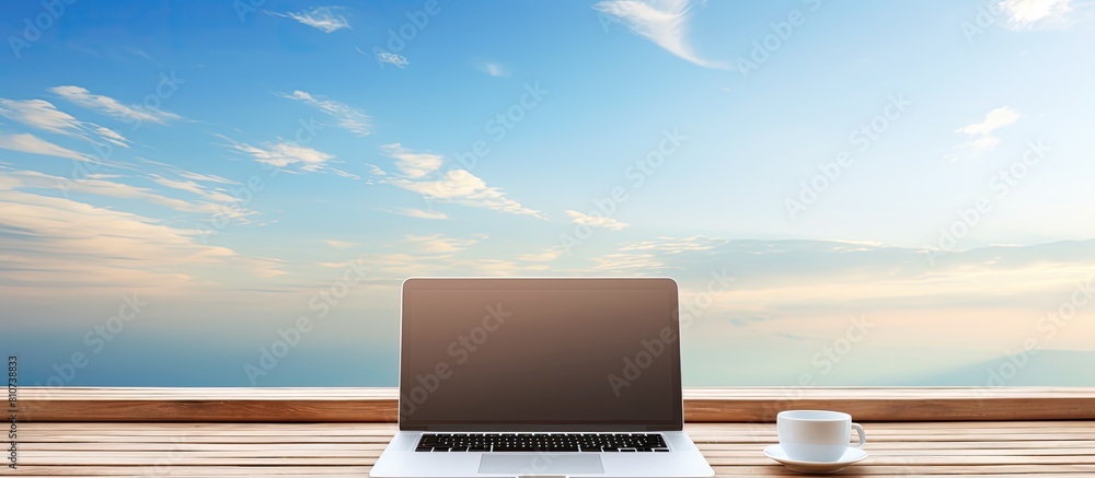 Aufkleber a laptop resting on a wooden table with a serene sky as the backdrop copy space image