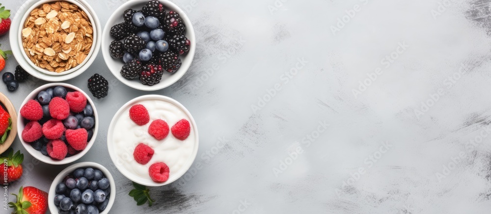 Aufkleber Top view of a collection of bowls filled with granola yogurt and berries placed on a grey background A visually appealing copy space image illustrating a variety of breakfast options to choose from