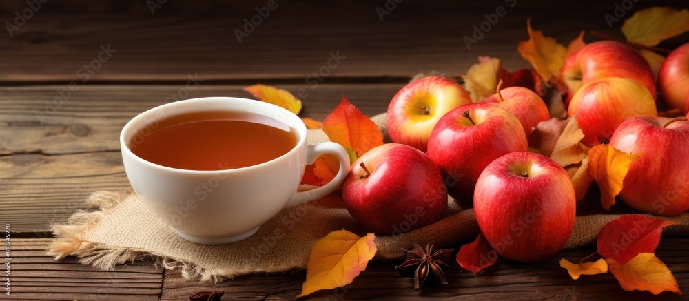 Poster autumn hot apple tea visually presented with ripe apples in a white cup on a wooden background perfe