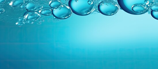 A vibrant macro abstract image showcases round bubbles of carbon dioxide floating in the translucent blue waters of the ocean providing ample copy space