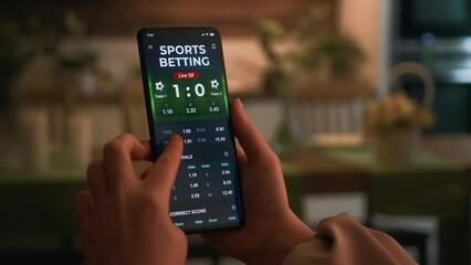 Making online bet on a gambling app. Watching live football score broadcast on a gambling smartphone application and gambling. Internet gambling concept.