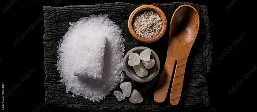 Poster top view of a spa set arrangement on a black background featuring sea salt a towel and a pumice ston