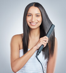 Portrait, beauty and woman smile with hair straightener in studio for style, treatment and shampoo...