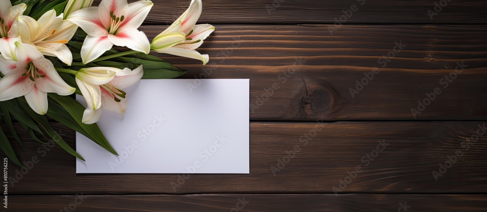 Aufkleber A copy space image of a white greeting card and craft envelope adorned with lilies flowers placed on a dark wooden background