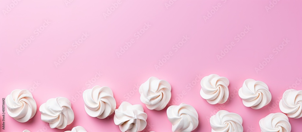 Poster a flat lay style image featuring homemade mini meringues in vibrant colors set against a pink backgr