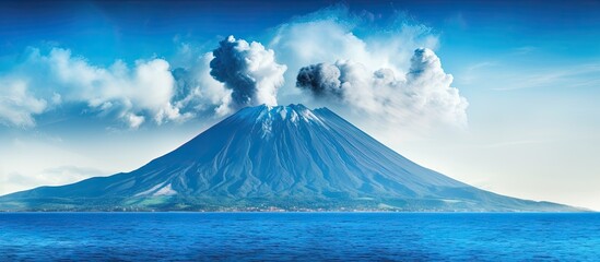 A vivid blue volcano rises from an oceanic island offering a captivating image with space for text...