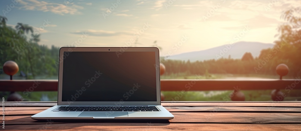 Poster A laptop resting on a wooden table with a serene sky as the backdrop Copy space image