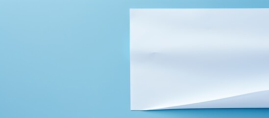 Fototapeta premium A white sheet of paper is placed on a blue background providing ample copy space for text The image showcases a print design concept