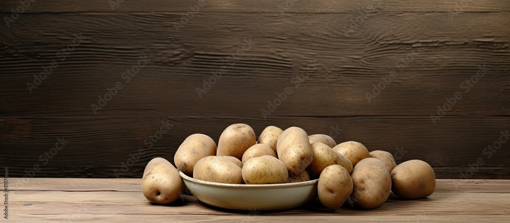 Poster a copy space image featuring a plate of uncooked potatoes is placed on a rustic wooden table