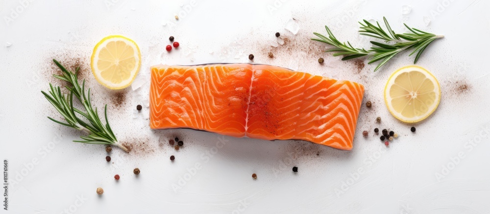 Poster a top down view of a raw salmon fillet seasoned with sea salt and rosemary placed on a white table w