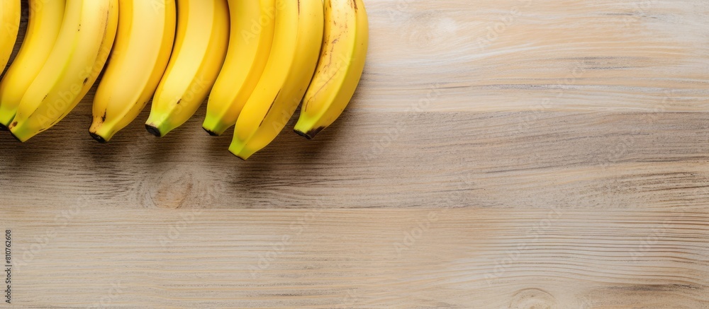 Fototapete A top view of three ripe bananas placed on a light wooden background leaving empty space for additional images or text